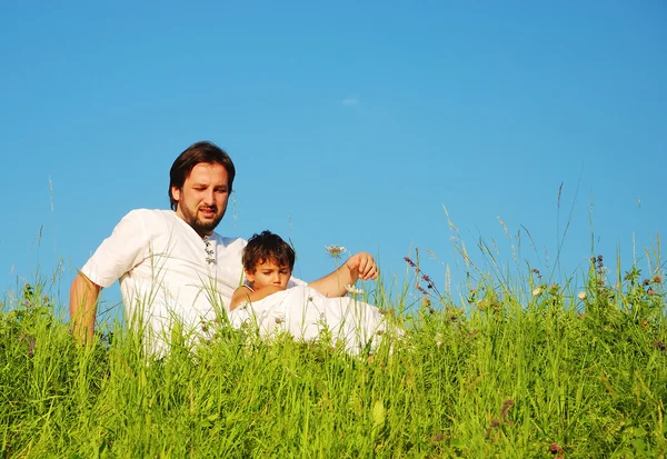 Μικρά πατέρας στα λευκά με το παιδί στο όμορφο λιβάδι — Φωτογραφία Αρχείου