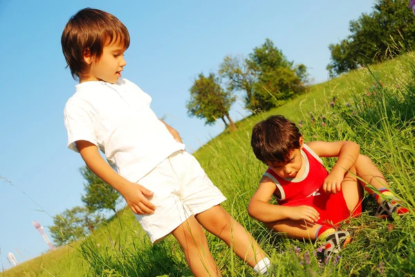 Pequenas crianças bonitos no belo campo verde — Fotografia de Stock