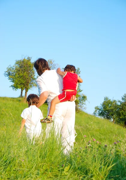 Padre joven en blanco con niños en el hermoso prado — Foto de Stock