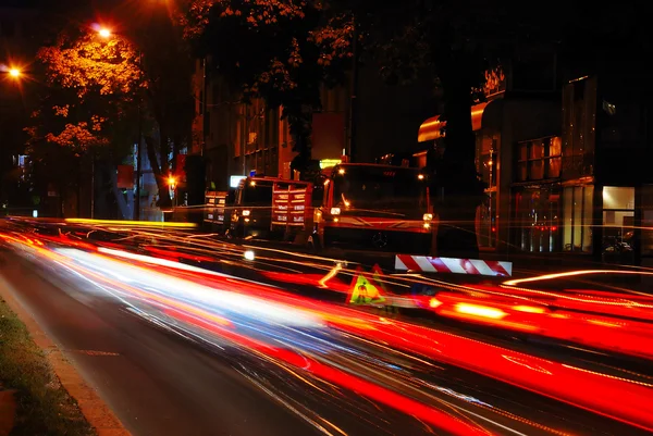 Colorful scene of traffic at night and workin area beside — Stock Photo, Image
