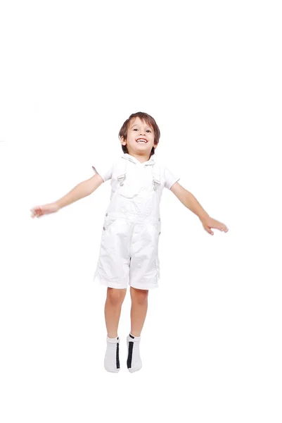 Happy little child in white clothes is jumping isolated — Stock Photo, Image