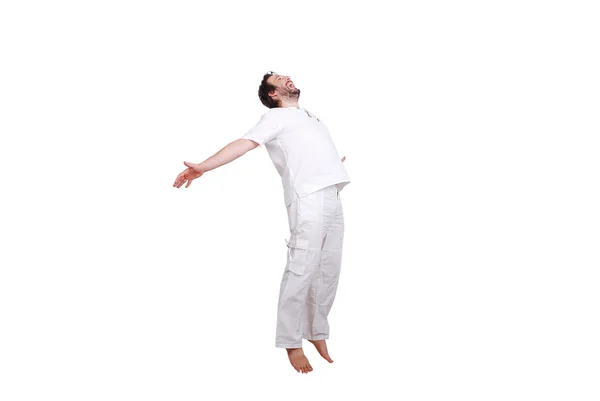 Felice giovane maschio in vestiti bianchi sta saltando isolato — Foto Stock