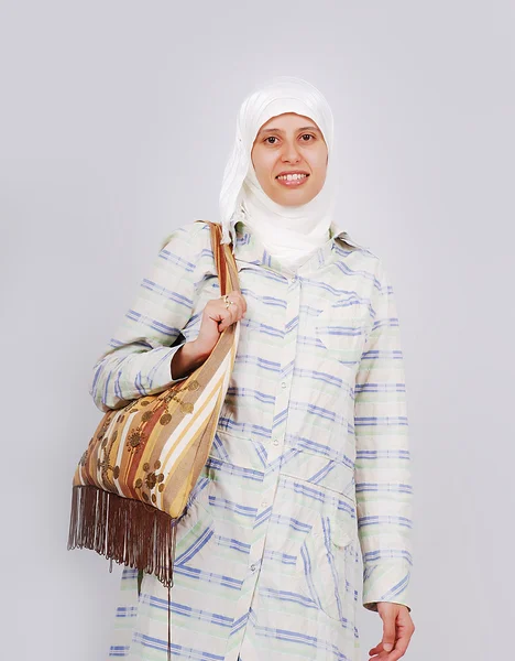 En ung muslimsk kvinna i traditionella kläder omsorg en väska — Stockfoto