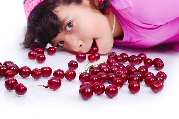 A cute girl beside many pieces of cherry Stock Picture