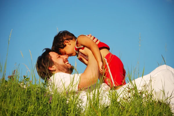 Young father in white with child on beautiful meadow Stock Photo