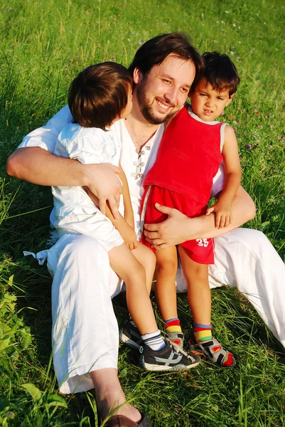 Jovem pai em branco com crianças no belo prado Imagens Royalty-Free