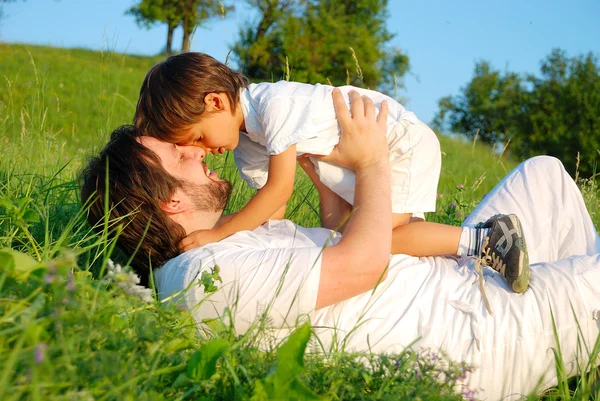 Padre joven en blanco con niño en el hermoso prado Imagen de archivo