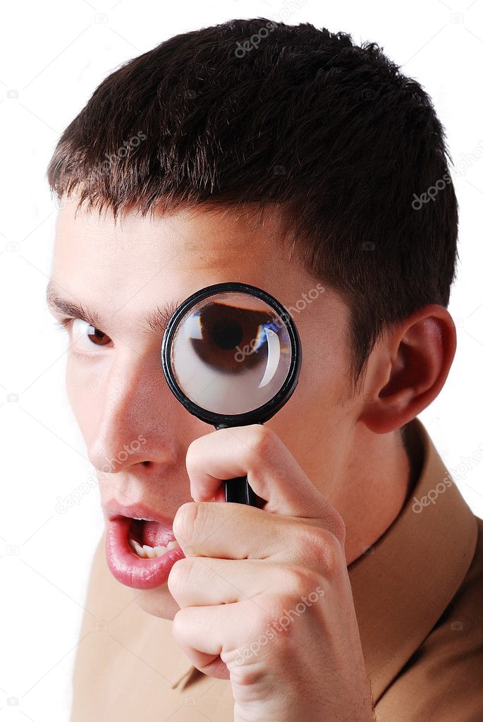 A young man searching with magnifier on eye