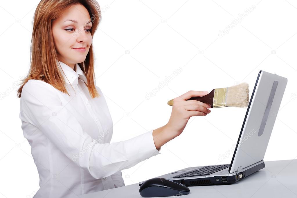 Female model is brushing, cleaning her laptop with brush