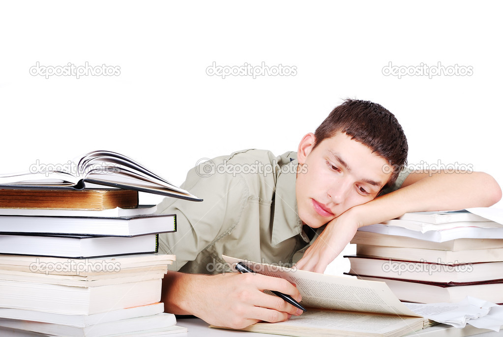 Young man with many books siting and writing