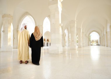 Muslim arabic couple inside big oriental empty modern building clipart