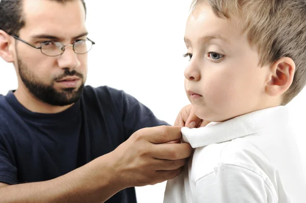 Portret van een kleine jongen geholpen door zijn vader in het dragen van shirt — Stockfoto