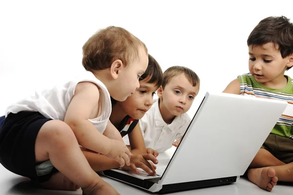 Grupo de niños jugando en el portátil blanco juntos. Aislado sobre blanco . —  Fotos de Stock