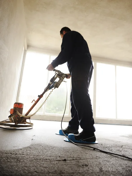 Equating and leveling fresh cement for the floor, by one worker — Stock Photo, Image