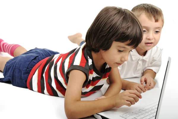 Csoport, a gyermekek játszanak a fehér laptop együtt. elszigetelt fehér. Stock Fotó