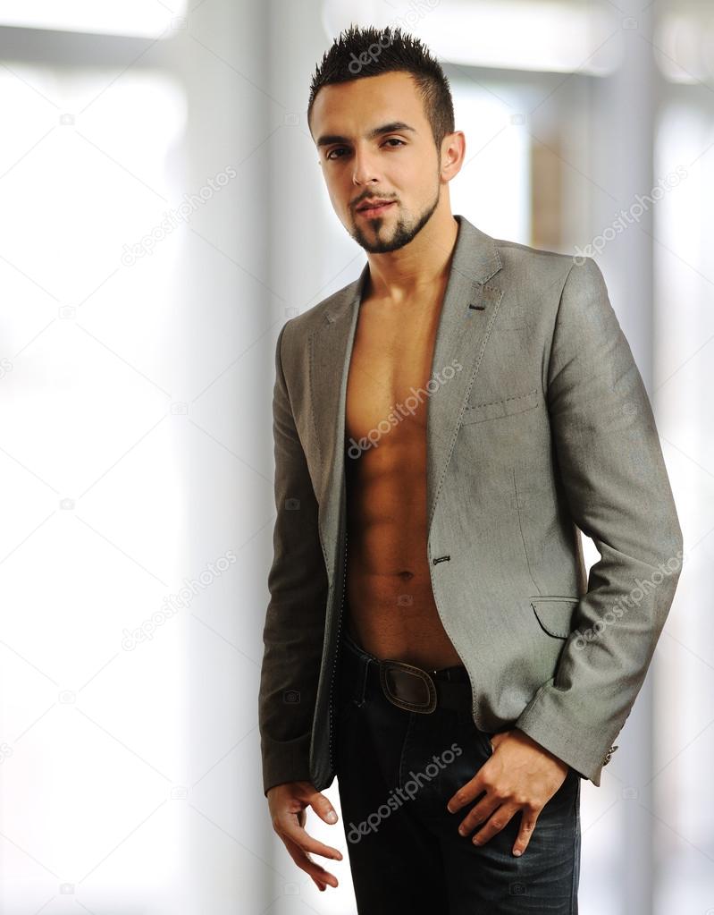 Image of a young stylish fashionable man standing near a window - Indoor