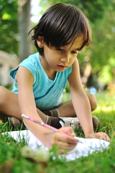 Writing kid boy, outdoor — стоковое фото