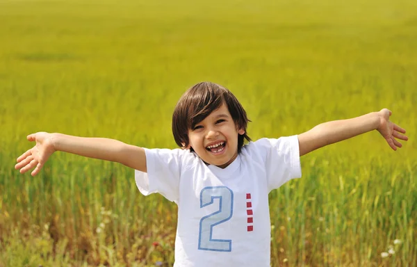 Felice ragazzo con le braccia aperte all'aperto — Foto Stock