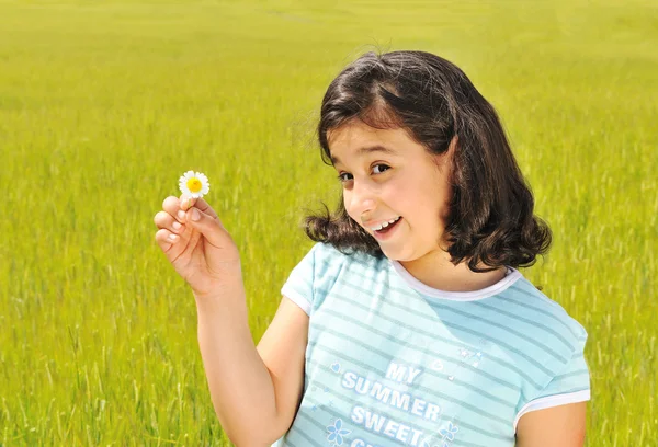 Menina feliz com flor branca sorrindo ao ar livre — Fotografia de Stock