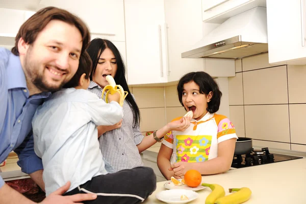 Счастливая семья из четырех человек на кухне — стоковое фото
