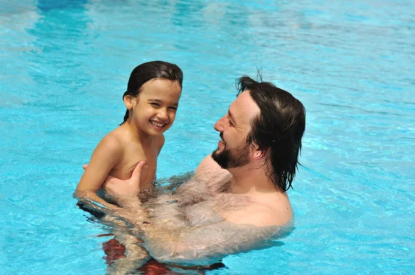 Gelukkig vader met zijn zoon in zwembad — Stockfoto