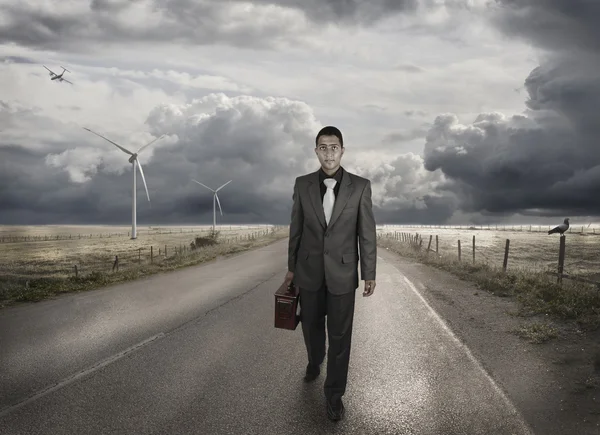 Un joven hombre de negocios caminando por el camino — Foto de Stock