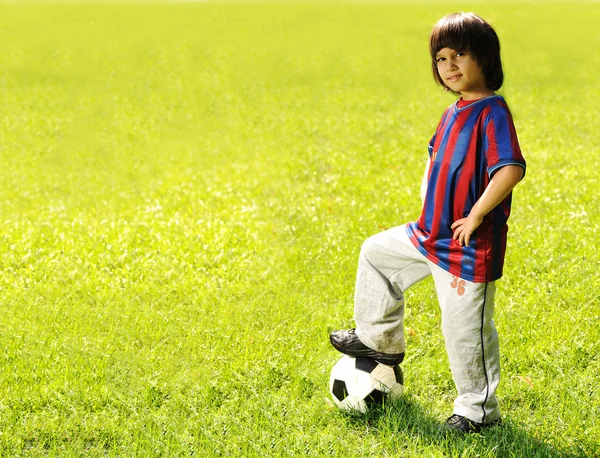 Garoto feliz jogando futebol em um parque ao ar livre — Fotografia de Stock