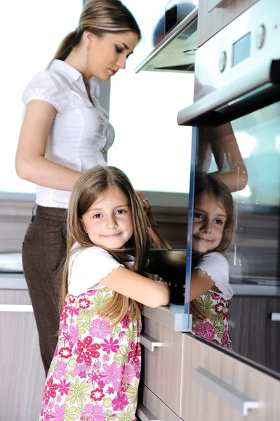 Young mother and little girl daughter in kitchen — Stock Photo, Image