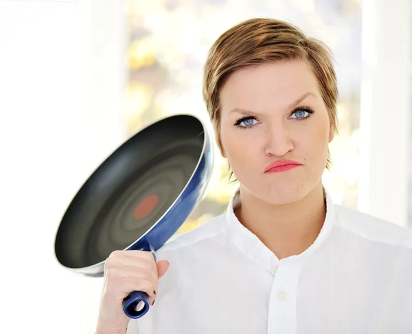 Beautiful young housewife with pan in hands — Stock Photo, Image