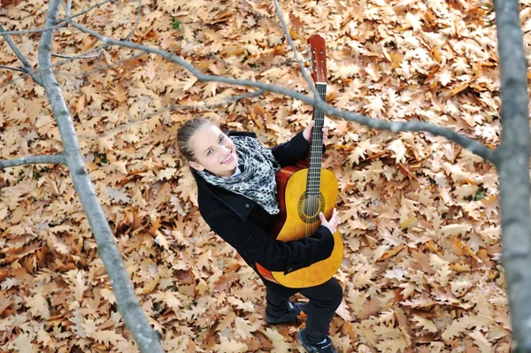 Flicka med gitarr utomhus — Stockfoto