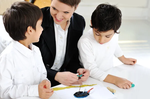 Mother working with sons on homework project — Stock Photo, Image