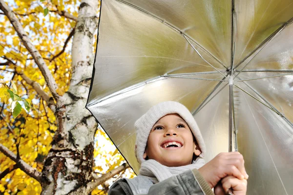 Niño feliz y hojas de otoño en un parque — Foto de Stock