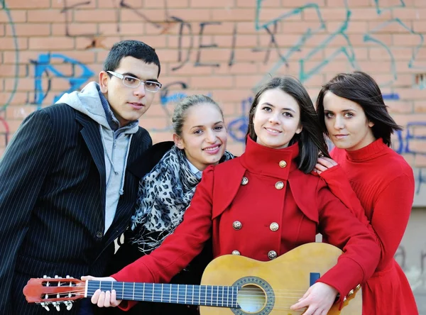 Adolescentes amigos tocando la guitarra en el parque de otoño —  Fotos de Stock