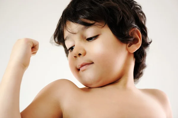 Criança mostrando os músculos de seus braços — Fotografia de Stock