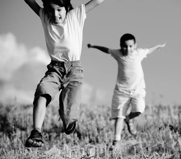 Two little boys on field running — Stock Photo, Image
