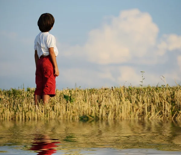 Kid standing on meadow alone — Stock Photo, Image