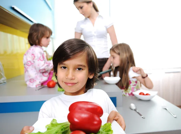 Liten pojke i köket matlagning med sin familj — Stockfoto