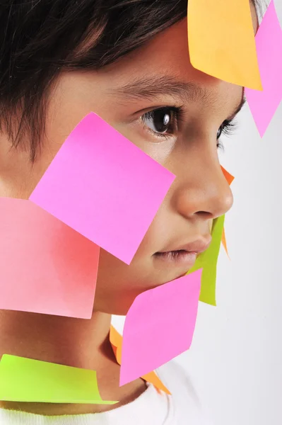 Menino com notas de memorando no rosto — Fotografia de Stock