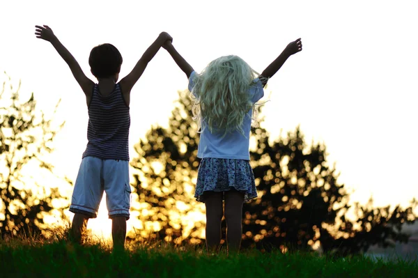 Niños felices en la naturaleza al atardecer —  Fotos de Stock