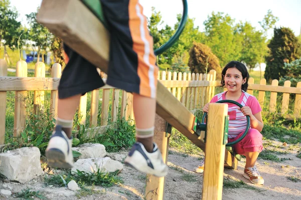 Kinder spielen auf Spielplatz mit Säge, Junge und Mädchen — Stockfoto