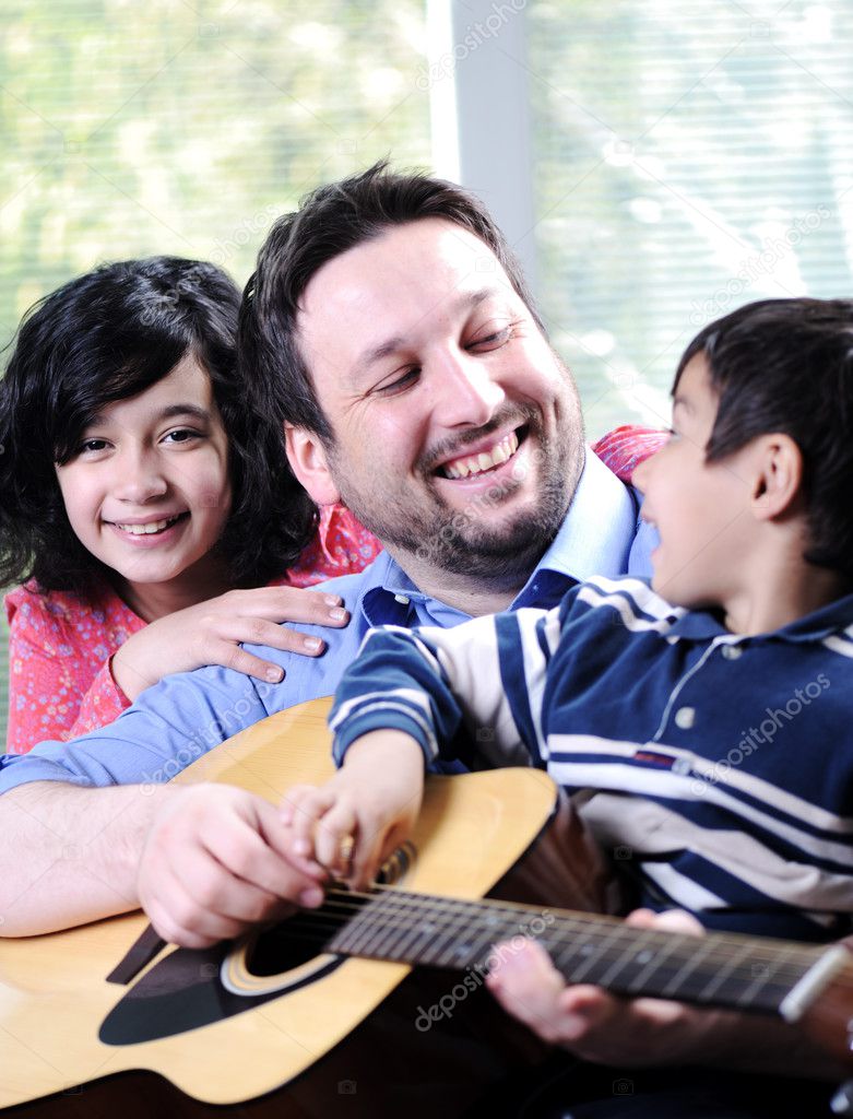 Happy family playing guitar together