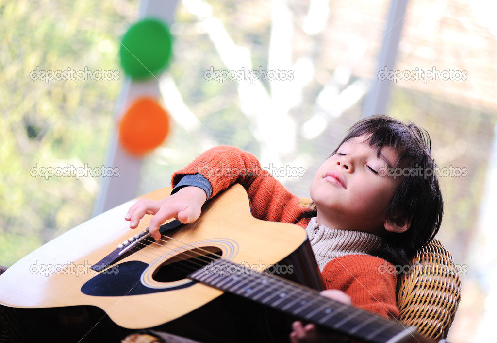 Kid playing guitar at home