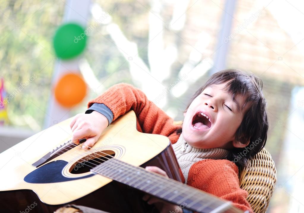 Kid singing and playing guitar at home