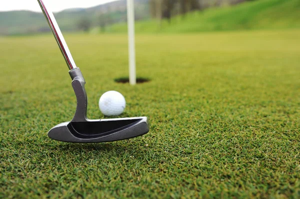 Golfball und Stock auf grünem Gras — Stockfoto