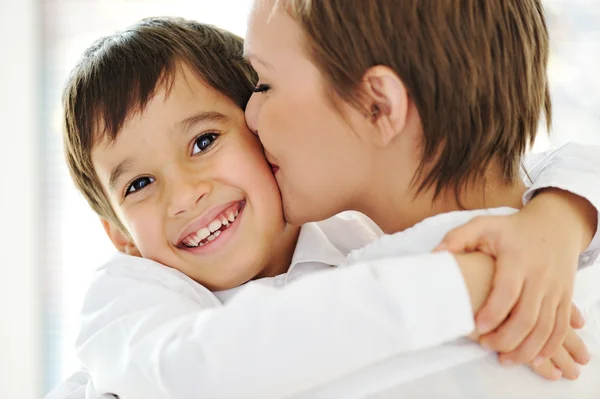 Gelukkig moeder omarmen en kussen haar zoon — Stockfoto