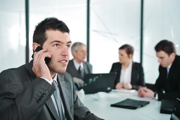 Деловой человек разговаривает по телефону во время встречи — стоковое фото