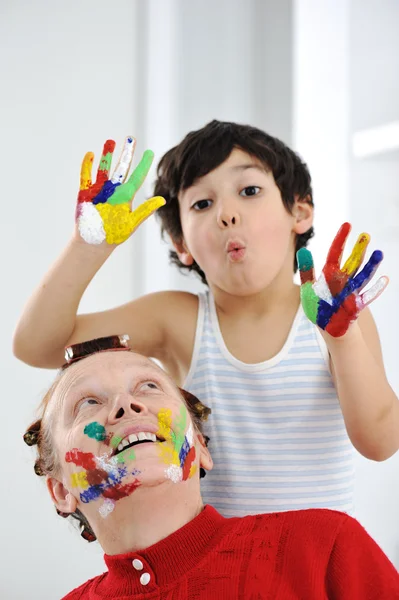 Kid och hans mamma leker med stökigt färger — Stockfoto