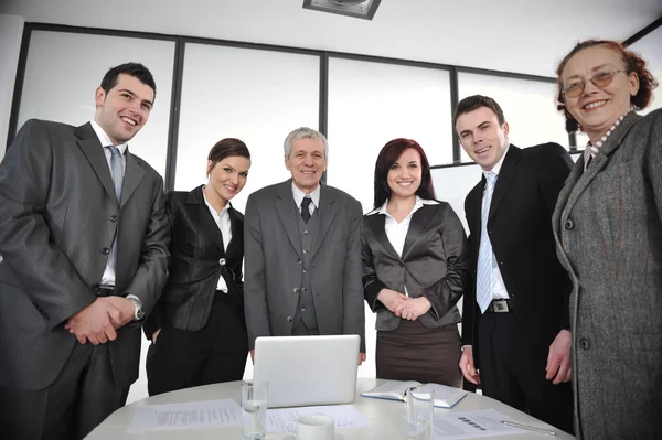 Negocios multiedad de pie alrededor de la mesa en la oficina — Foto de Stock