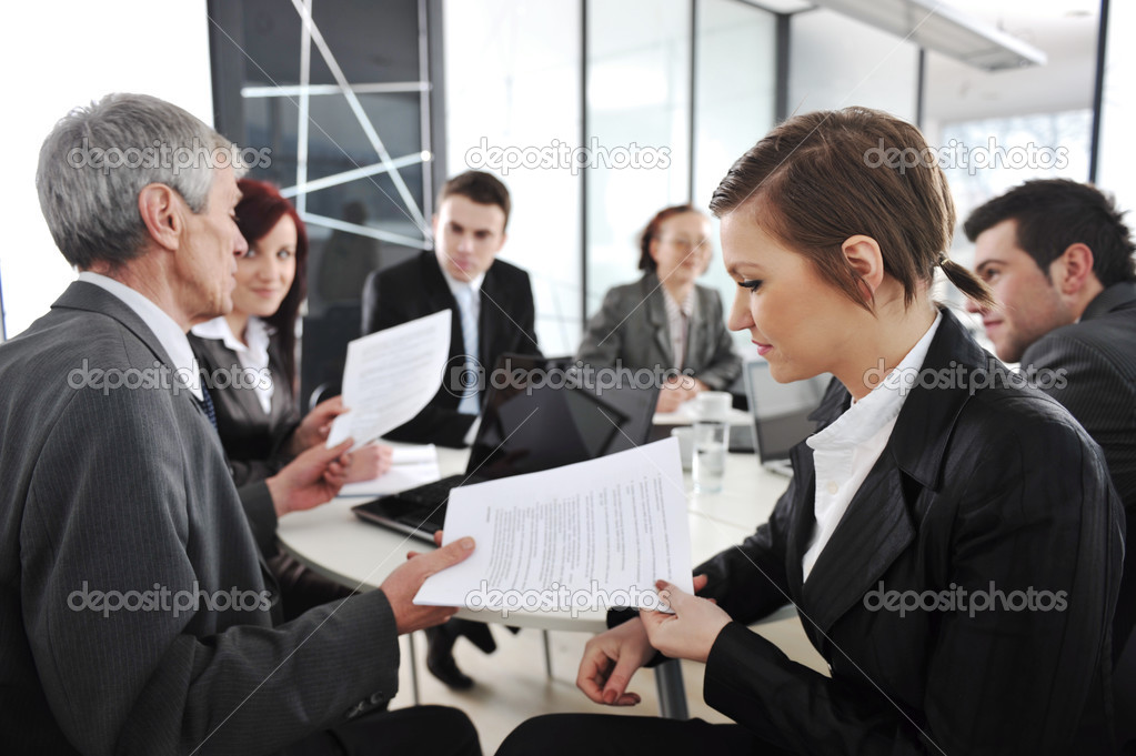 Young businesswoman in business meeting at office with colleagues in background