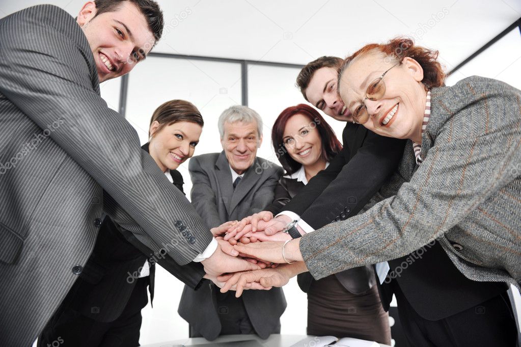 Group of happy smiling executives placing their hands together